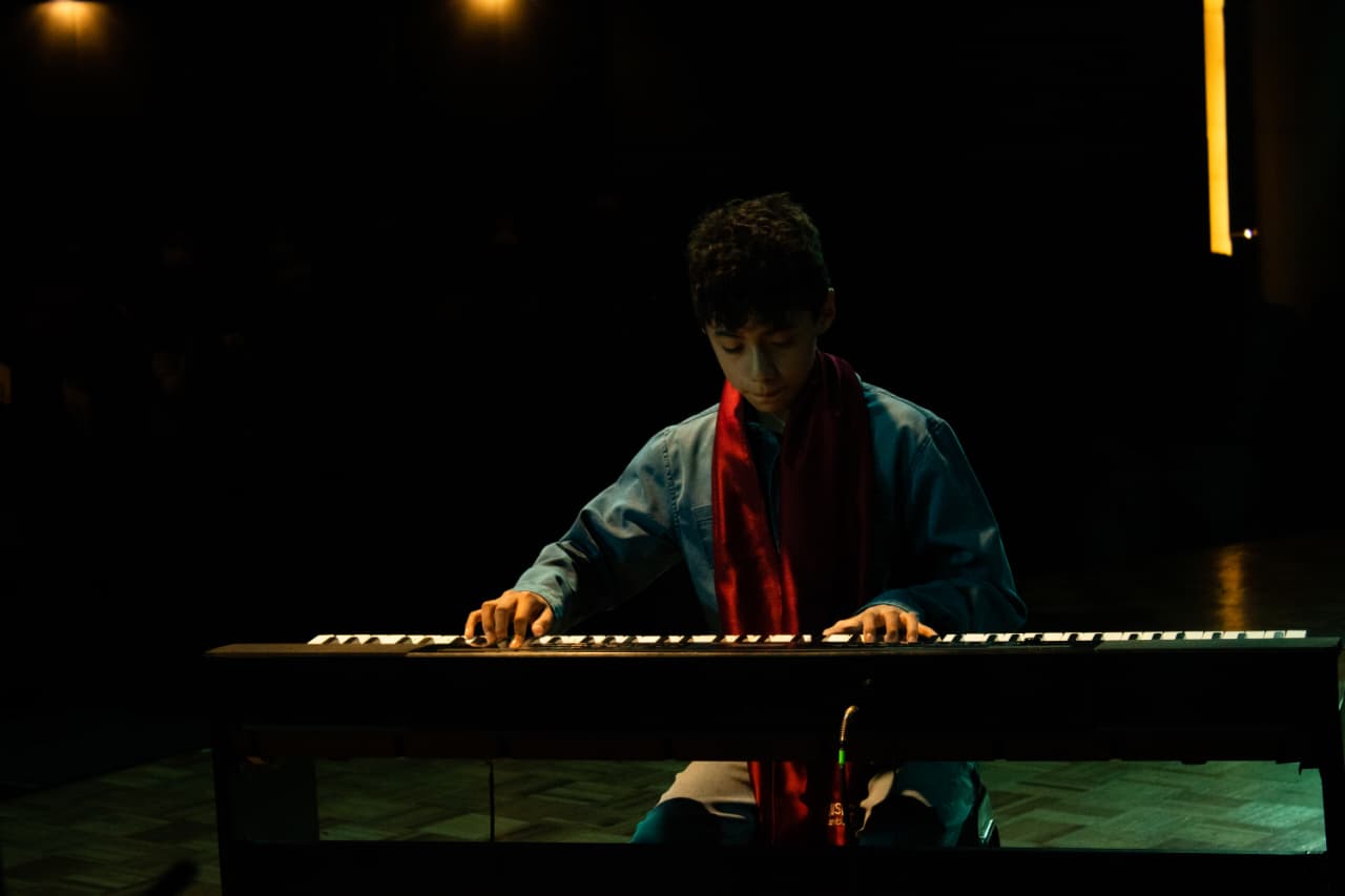 Estudiante tocando piano durante una presentación